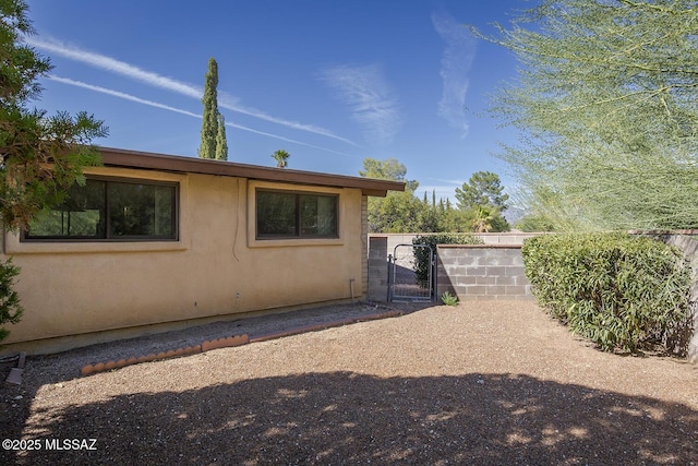 view of property exterior featuring a gate and stucco siding