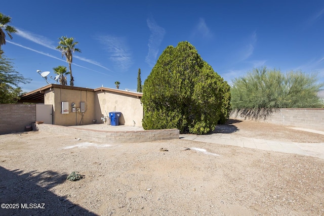 exterior space featuring a fenced backyard and stucco siding