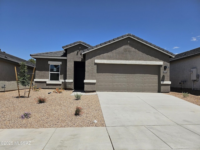 9817 E Gray Hawk Dr, Tucson, AZ 85730 - ranch-style home featuring concrete driveway, stucco siding, a tile roof, and a garage