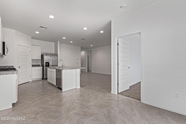 9817 E Gray Hawk Dr, Tucson, AZ 85730 - kitchen with visible vents, appliances with stainless steel finishes, recessed lighting, white cabinetry, and an island with sink