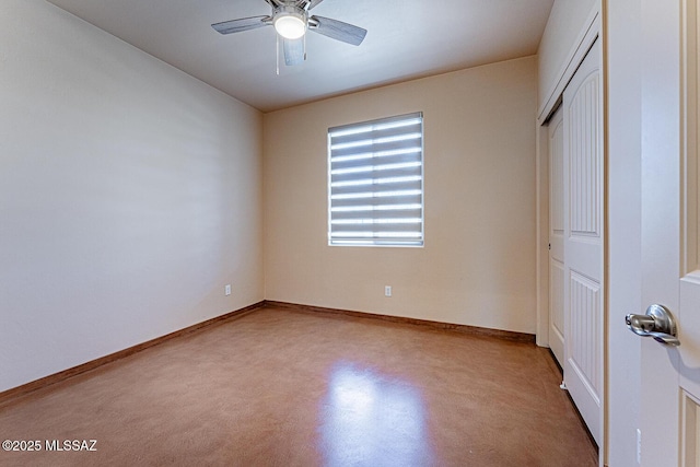 unfurnished bedroom with finished concrete flooring, baseboards, a ceiling fan, and a closet