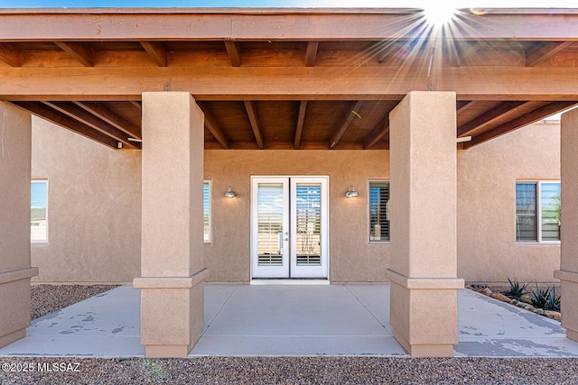 doorway to property with a patio area, stucco siding, and french doors