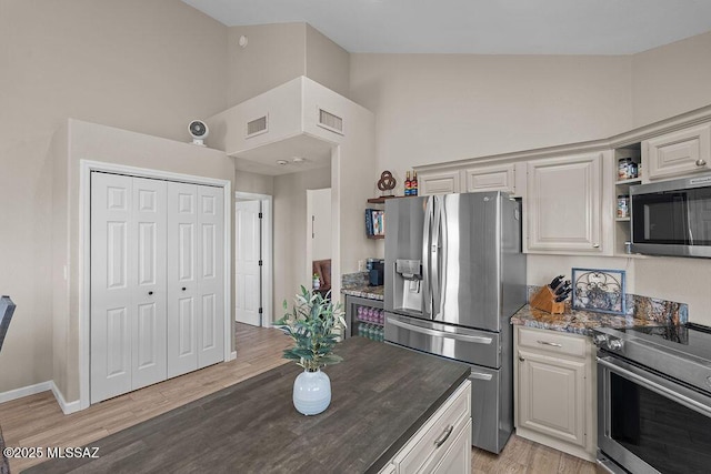 14171 N Gibson Trl, Tucson, AZ 85755 - kitchen featuring appliances with stainless steel finishes, high vaulted ceiling, dark stone countertops, light wood finished floors, and open shelves
