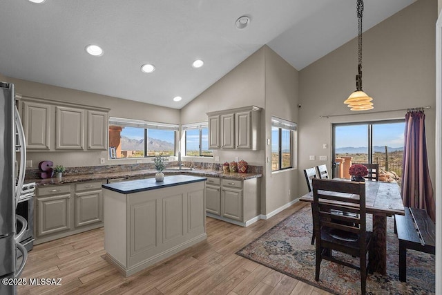 14171 N Gibson Trl, Tucson, AZ 85755 - kitchen with high vaulted ceiling, a kitchen island, plenty of natural light, light wood-style flooring, and decorative light fixtures