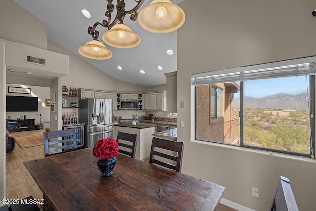 14171 N Gibson Trl, Tucson, AZ 85755 - dining room featuring light wood-style flooring, high vaulted ceiling, recessed lighting, a mountain view, and baseboards