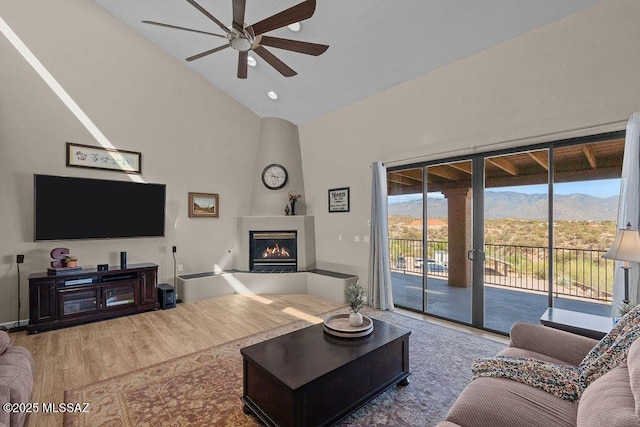 14171 N Gibson Trl, Tucson, AZ 85755 - living area featuring ceiling fan, high vaulted ceiling, wood finished floors, a mountain view, and a large fireplace