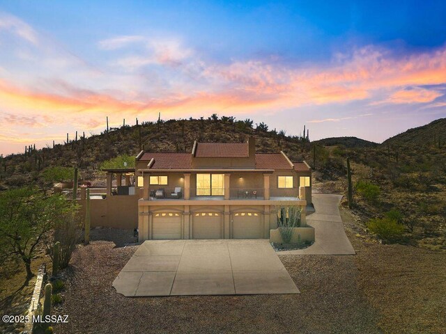 14171 N Gibson Trl, Tucson, AZ 85755 - view of front facade with a balcony, driveway, an attached garage, stucco siding, and a mountain view