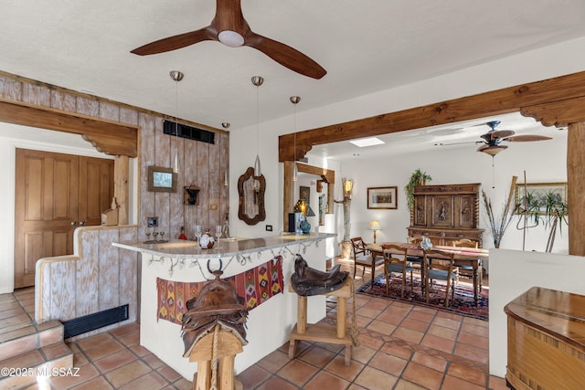 kitchen with a peninsula, ceiling fan, visible vents, and tile patterned flooring
