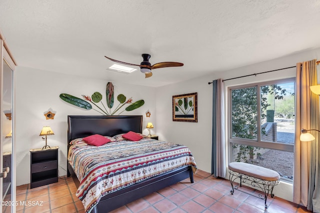 bedroom featuring a ceiling fan, a textured ceiling, and light tile patterned floors