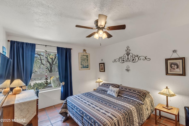 bedroom with a textured ceiling, tile patterned floors, and ceiling fan