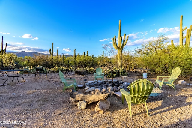 view of yard with a mountain view and an outdoor fire pit