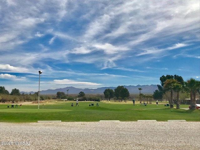 view of community with a mountain view, a yard, and golf course view