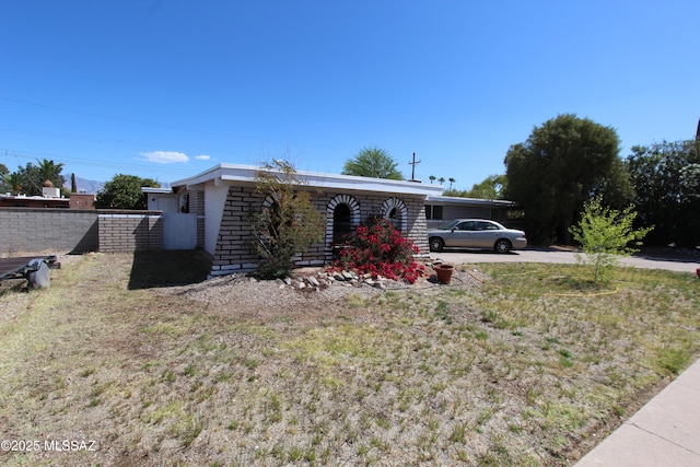 view of front of house featuring fence and a front lawn