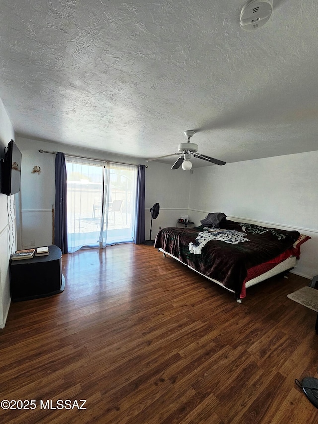 bedroom featuring a ceiling fan, a textured ceiling, and wood finished floors