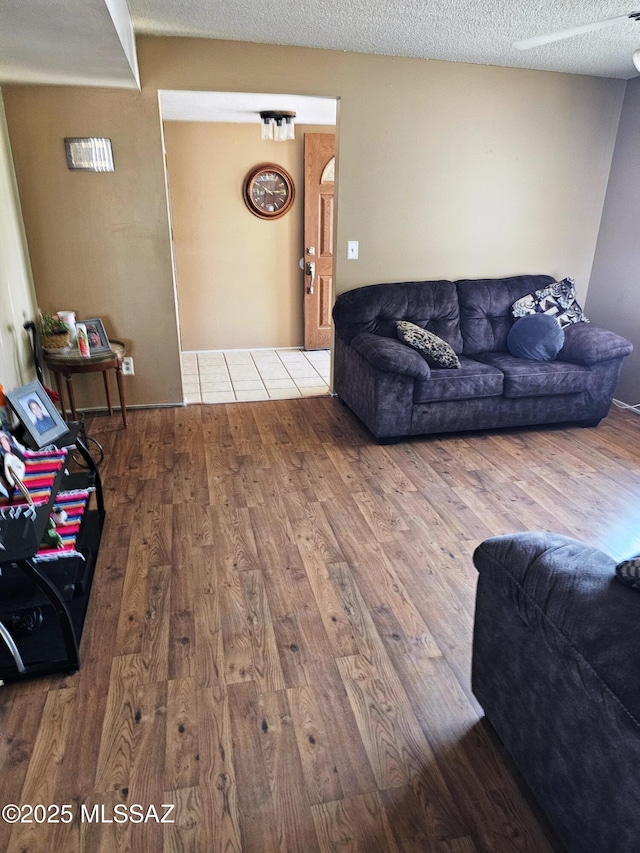 living room with a textured ceiling and wood finished floors