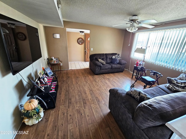 living area featuring a textured ceiling, ceiling fan, and wood finished floors