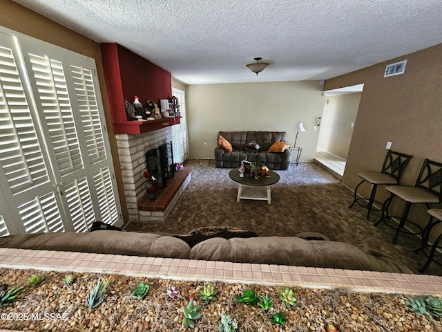 living room featuring a textured ceiling, visible vents, carpet, and a fireplace