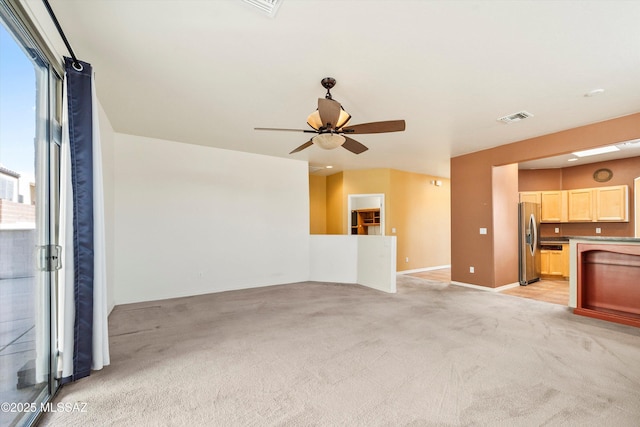 unfurnished living room featuring baseboards, ceiling fan, visible vents, and light colored carpet