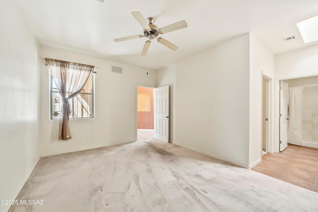 empty room featuring carpet, a ceiling fan, and visible vents