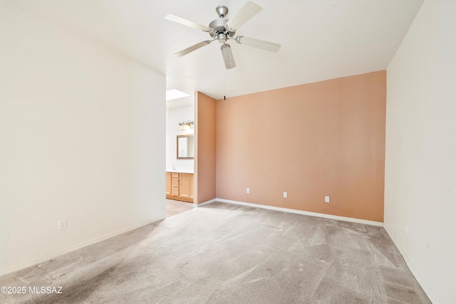 empty room with baseboards, light carpet, and ceiling fan