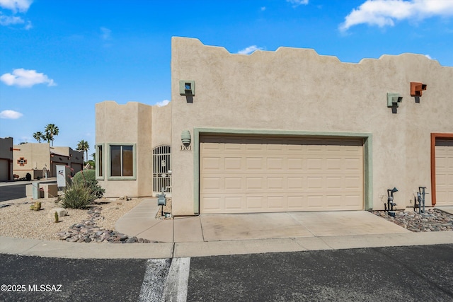 pueblo revival-style home with stucco siding and driveway