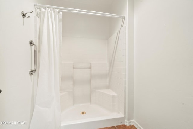 bathroom featuring baseboards and a stall shower
