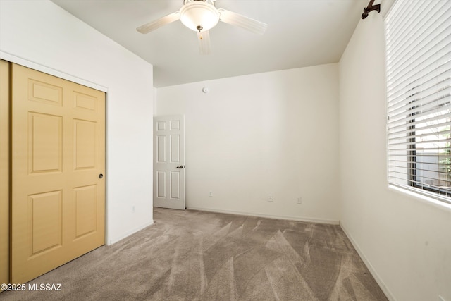 unfurnished bedroom featuring baseboards, ceiling fan, and carpet