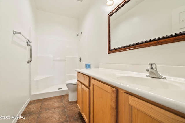 bathroom with toilet, a tile shower, tile patterned floors, baseboards, and vanity