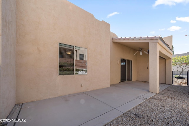 back of house with stucco siding, ceiling fan, and a patio