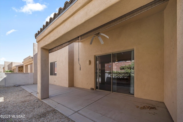 back of property with stucco siding, fence, a ceiling fan, and a patio