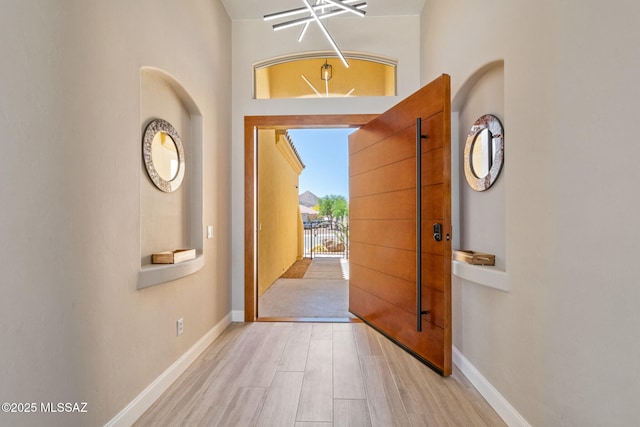 foyer entrance with baseboards and wood finished floors