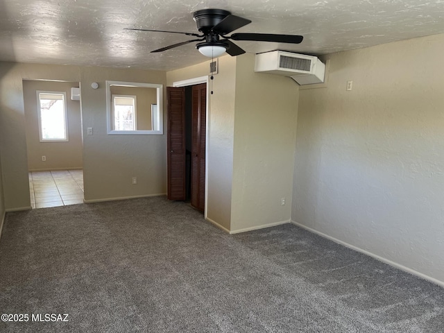 spare room with visible vents, carpet flooring, baseboards, and ceiling fan