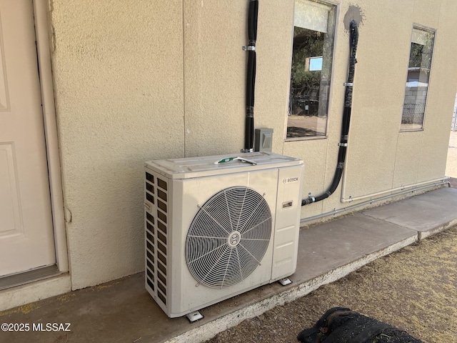 exterior details with ac unit and stucco siding