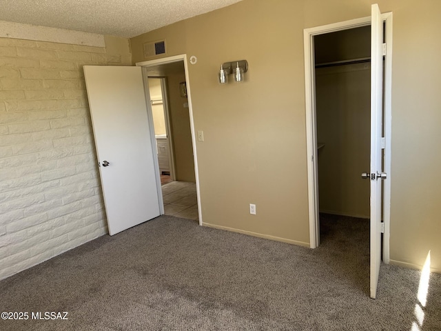 unfurnished bedroom with carpet floors, visible vents, a spacious closet, and a closet