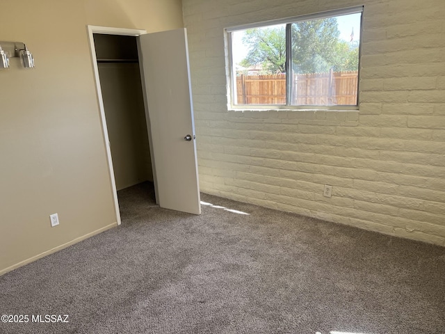 unfurnished bedroom featuring carpet floors, a closet, and a spacious closet