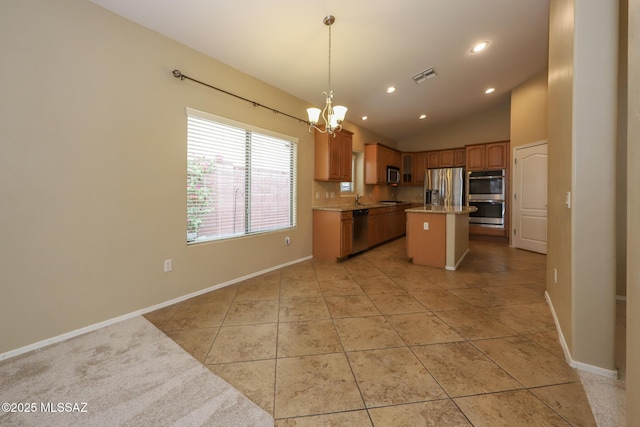 651 W Sonatina Ln, Oro Valley, AZ 85737 - kitchen with appliances with stainless steel finishes, a chandelier, a kitchen island, lofted ceiling, and light tile patterned floors