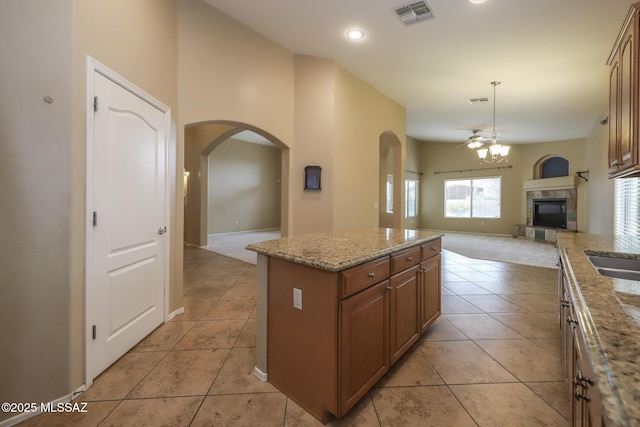 651 W Sonatina Ln, Oro Valley, AZ 85737 - kitchen with arched walkways, a glass covered fireplace, open floor plan, light tile patterned floors, and recessed lighting