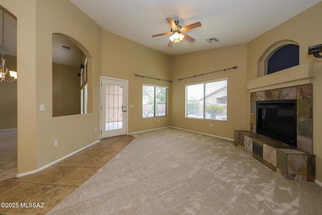 651 W Sonatina Ln, Oro Valley, AZ 85737 - unfurnished living room featuring a tile fireplace, ceiling fan, a chandelier, baseboards, and carpet floors