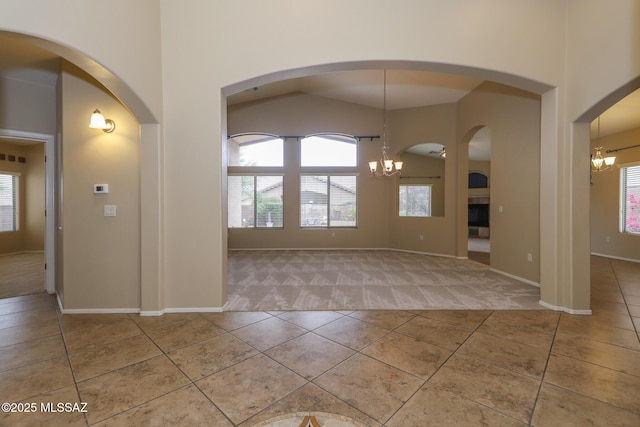 651 W Sonatina Ln, Oro Valley, AZ 85737 - carpeted spare room featuring a chandelier, tile patterned floors, baseboards, and a towering ceiling