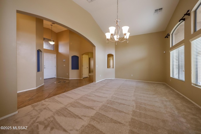 651 W Sonatina Ln, Oro Valley, AZ 85737 - spare room with arched walkways, high vaulted ceiling, a chandelier, carpet flooring, and tile patterned flooring
