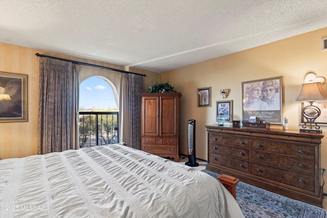 bedroom with access to outside, a textured ceiling, and visible vents