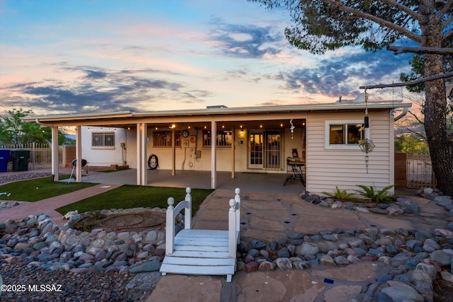 rear view of property featuring a patio area and fence