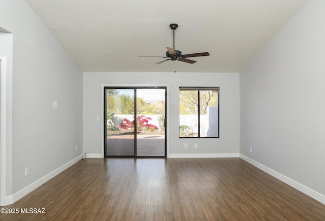 unfurnished room with baseboards, a ceiling fan, and dark wood-type flooring