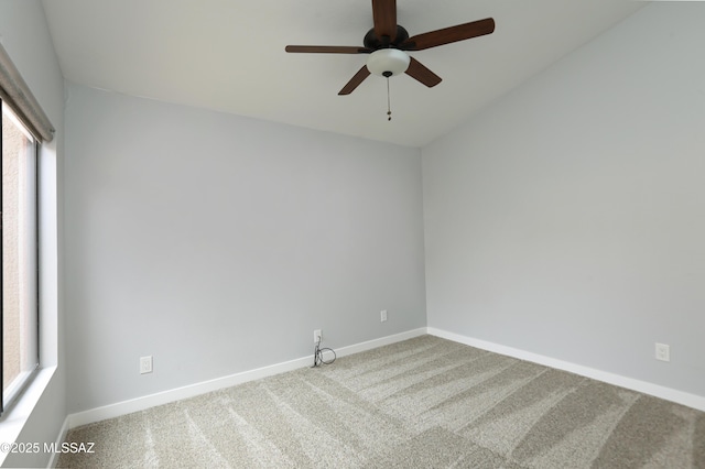 carpeted empty room with a ceiling fan and baseboards