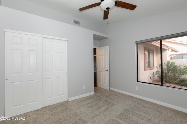 unfurnished bedroom with a ceiling fan, visible vents, baseboards, a closet, and carpet flooring