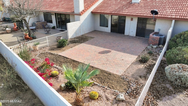 exterior space with fence, stucco siding, and a tile roof