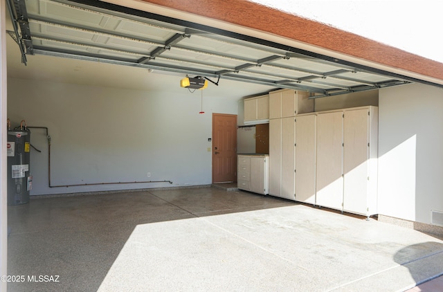 garage with visible vents, a garage door opener, and electric water heater