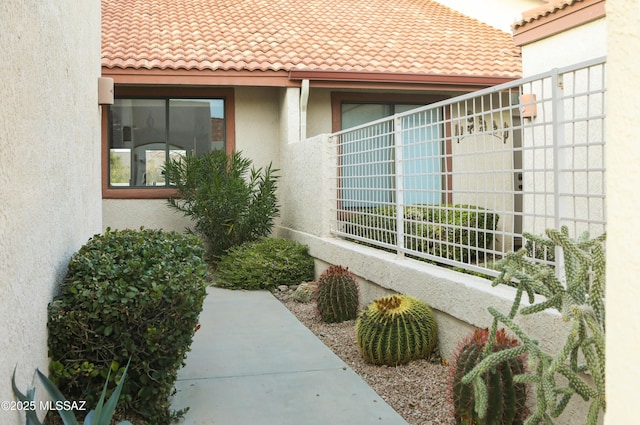 view of property exterior with stucco siding and a tiled roof