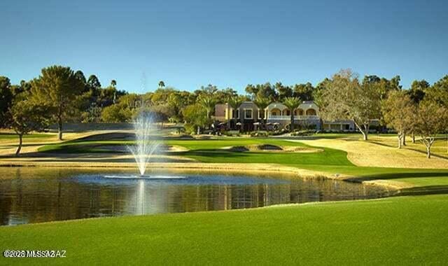 view of home's community featuring a yard, a water view, and golf course view