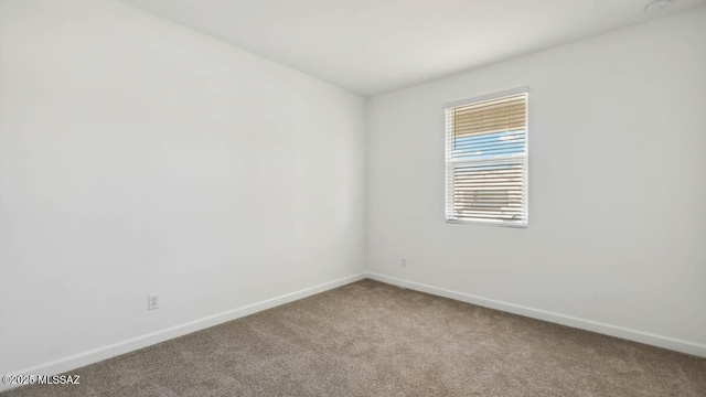 carpeted empty room with baseboards